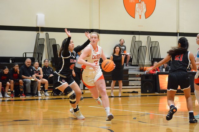 Caltech athlete Claire Perhach dribbles basketball past a defender.