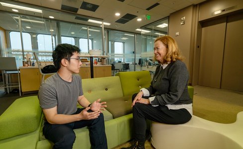Brian Nguyena and Julie Schoenfeld share discussion while seated in an office environment.