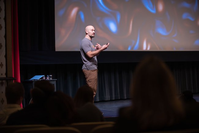 Tanner Harms delivers a Science Journey talk on stage.