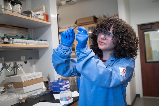 Wendy Granados Razo working in the laboratory wearing gloves and protective eyewear.