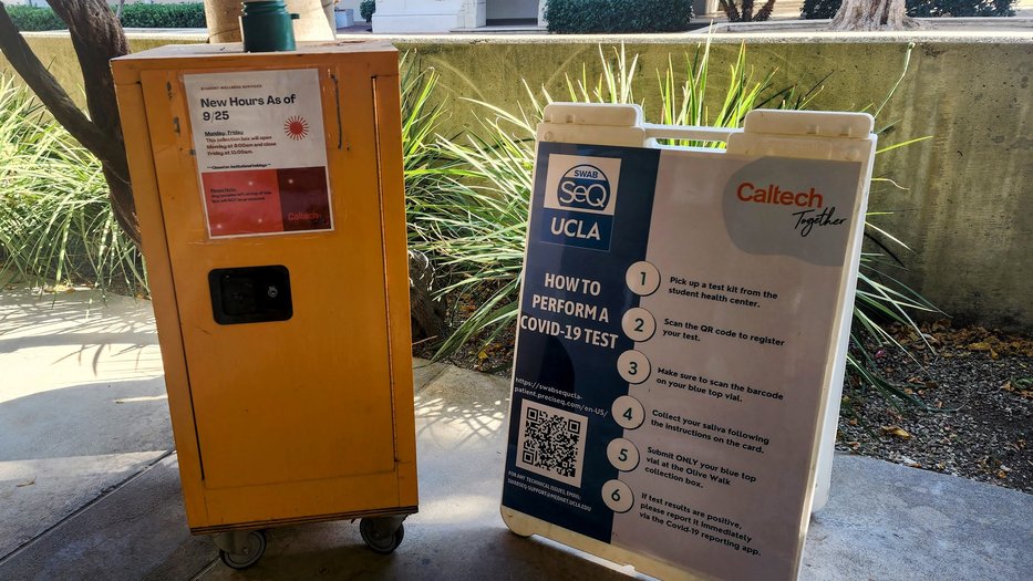 Yellow collection box next to a sign with instructions on how to perform a COVID test