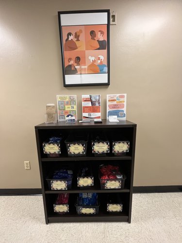 A bookshelf containing baskets of condoms and other barrier contraception