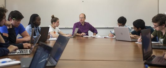 Frederick Eberhardt and students seated around a large table