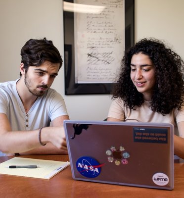 Two undergraduate students looking at a laptop screen
